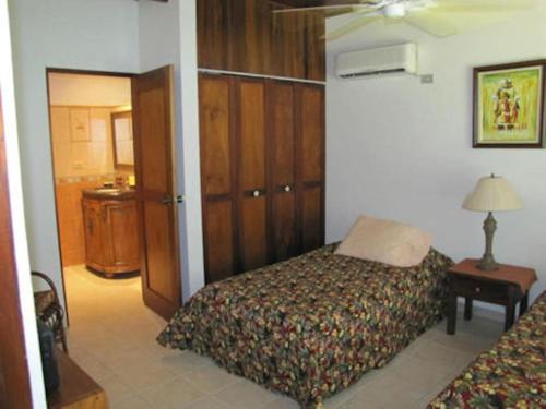 a bedroom with a bed and a table with a lamp at Splendide villa avec piscine à 200m de l'océan. in Parrita