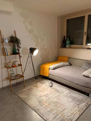 1 dormitorio con cama, lámpara y alfombra en Privatzimmer 500 m zur Messe München, en Haar