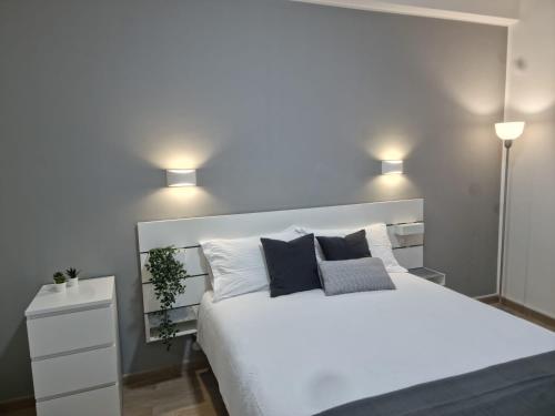 a bedroom with a large white bed with two lights at Civico 29 apartment in Messina