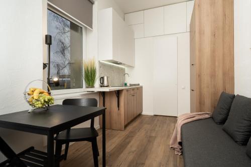 - un salon avec une table et un canapé dans l'établissement Air Apartment 211, à Vilnius