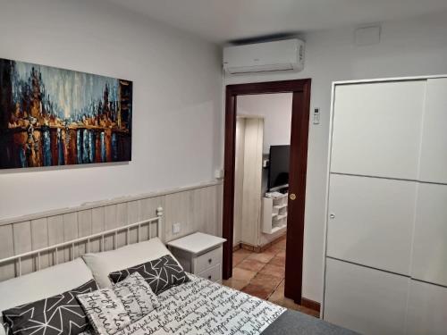 a bedroom with a bed and a painting on the wall at La Casa de los Patos in Toledo