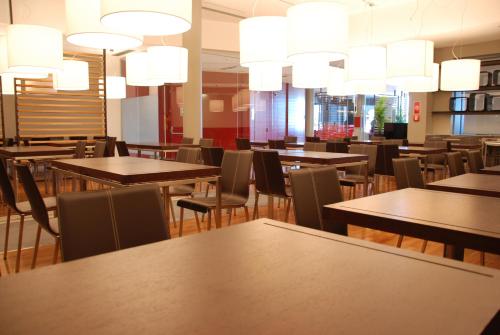a restaurant with tables and chairs and chandeliers at Sea Art Hotel in Vado Ligure