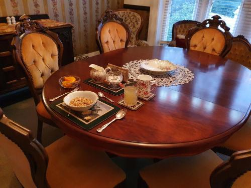 a wooden table with bowls of food on it at Dalkeith Boutique Bed & Breakfast in Kaiapoi