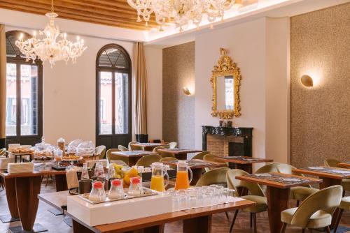 a restaurant with tables and chairs and a chandelier at Salute Palace powered by Sonder in Venice