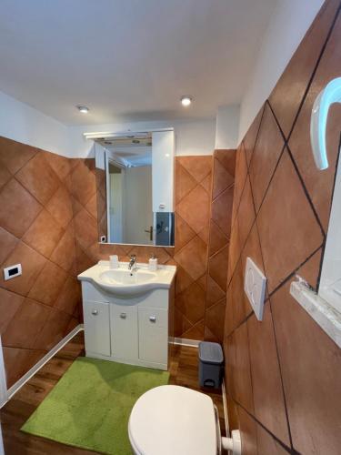 uma casa de banho com um lavatório, um WC e um espelho. em Il Casale di B em Acilia