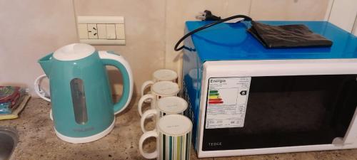 a kitchen counter with a microwave and a tea kettle at Departamento ANGOSTURA in General Alvear