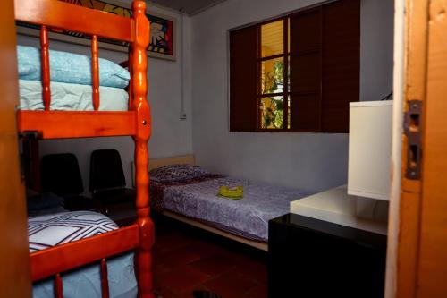 1 Schlafzimmer mit 2 Etagenbetten und einem Schreibtisch in der Unterkunft Caminhos de Caravaggio - Hostel Parada dos Caminhantes in Nova Palmira