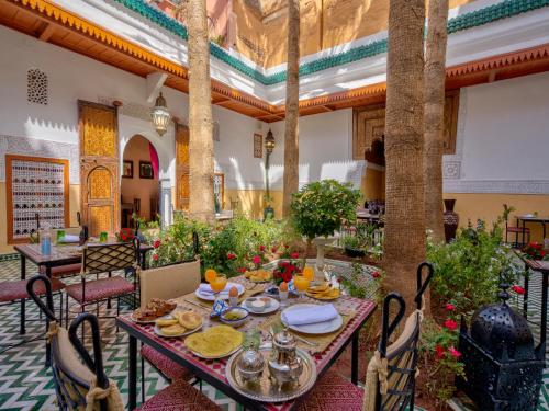 een tafel met eten erop in een kamer met bomen bij Palais Tinmel Marrakech in Marrakesh