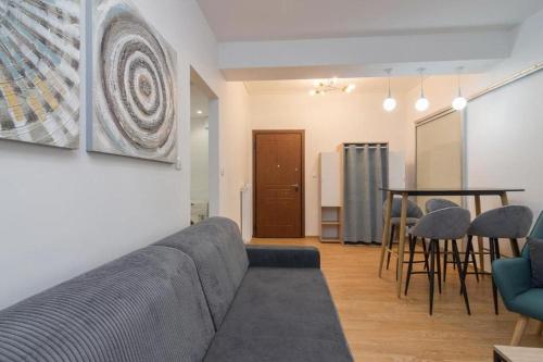 a living room with a couch and a table and chairs at Fully renovated 1 bedroom condo in Athens