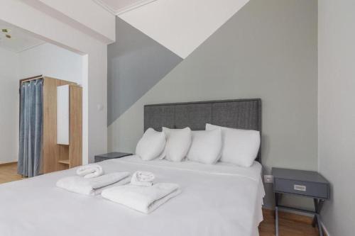 a bedroom with a white bed with towels on it at Fully renovated 1 bedroom condo in Athens