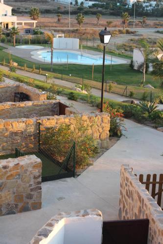 een uitzicht op een park met een zwembad en een straatlicht bij CASA ROMPEOLAS Atlanterra in Zahara de los Atunes