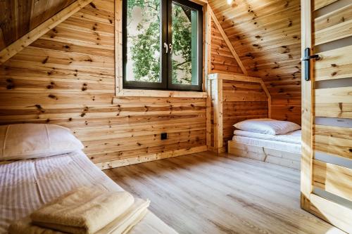 ein Schlafzimmer mit 2 Betten im Blockhaus in der Unterkunft Domki na Kaszubach - Chabry i Rumianki - Roztoka, Przywidz - Basen Sauna Jacuzzi 