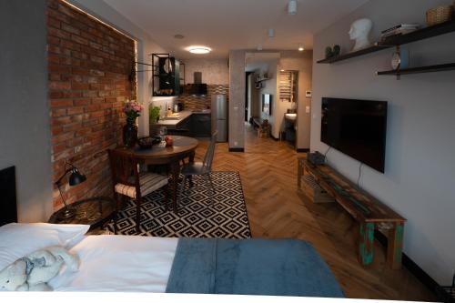 um quarto com uma cama, uma televisão e uma cozinha em Arte Apartments - Old Town Gdańsk em Gdansk