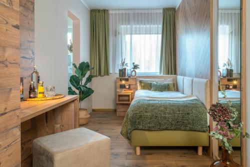 1 dormitorio con cama, mesa y ventana en Feinheit Hotel & Restaurant, en Halsenbach