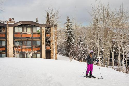a person on skis in the snow in front of a building at Laurelwood Condominiums 403 in Snowmass Village