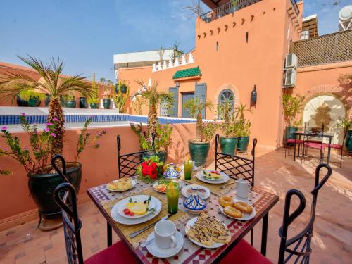 een tafel met ontbijtproducten op een patio bij Palais Tinmel Marrakech in Marrakesh