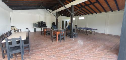 a dining room with tables and chairs in a building at Hospedaje Campestre El Deseo in El Caimo