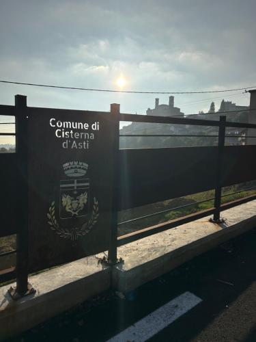 a sign on a fence with a train in the background at Takápradalù in Cisterna dʼAsti