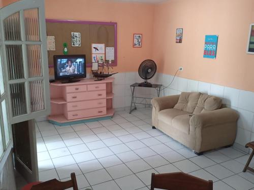 uma sala de estar com um sofá e uma televisão em Hostel & Pousada UFPE INN no Recife
