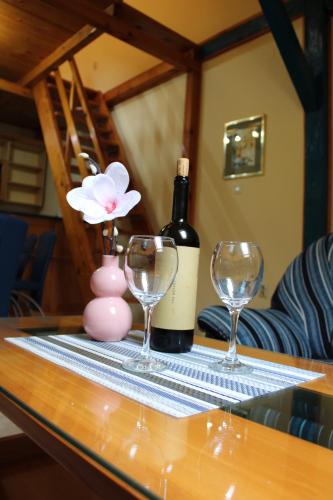 a table with a bottle of wine and two wine glasses at Siesta in Kikinda
