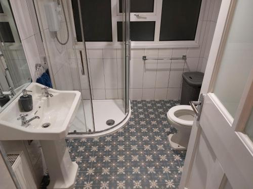 a bathroom with a shower and a sink and a toilet at Jack's Place 3-Bed House Donegal Sleeps 5 in Stranorlar