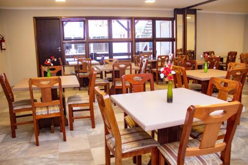 een restaurant met tafels, stoelen en ramen bij HOTEL DOMHOF in Blumenau