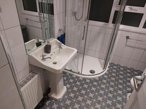 a bathroom with a sink and a shower at Jack's Place Beautiful 3-Bed House Donegal in Stranorlar