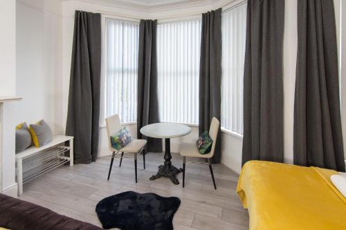 a bedroom with a bed and a table and chairs at 147 The Residence - 5 Bedrooms - Free Parking - Belfast in Belfast