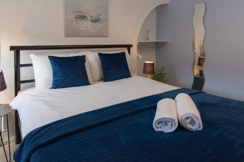 a bedroom with a blue and white bed with towels on it at 147 The Residence - 5 Bedrooms - Free Parking - Belfast in Belfast