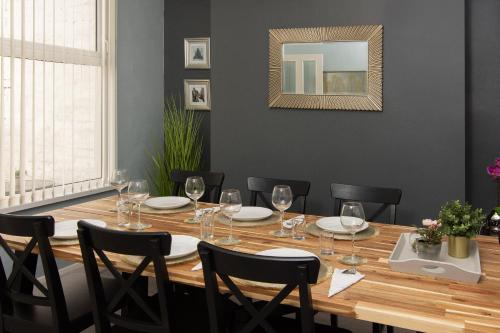 a dining room with a table with chairs and a mirror at 147 The Residence - 5 Bedrooms - Free Parking - Belfast in Belfast