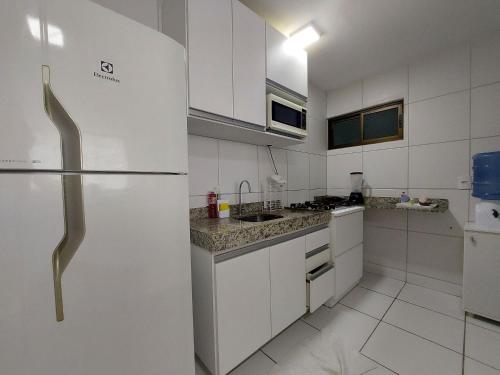 uma cozinha com armários brancos e um frigorífico em Apartamento Encanto próximo ao Pátio do forró em Caruaru