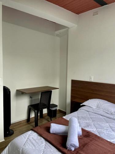 um quarto com uma cama e uma secretária com toalhas em La Patrona em Falan