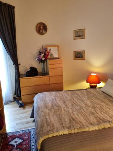 ein Schlafzimmer mit einem Bett, einer Kommode und einer Lampe in der Unterkunft Moulin Vieux in Saint-Palais-sur-Mer