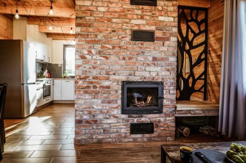 a brick wall with a fireplace in a kitchen at Domki na Kaszubach - Chabry i Rumianki - Roztoka, Przywidz - Basen Sauna Jacuzzi KASZUBY in Roztoka