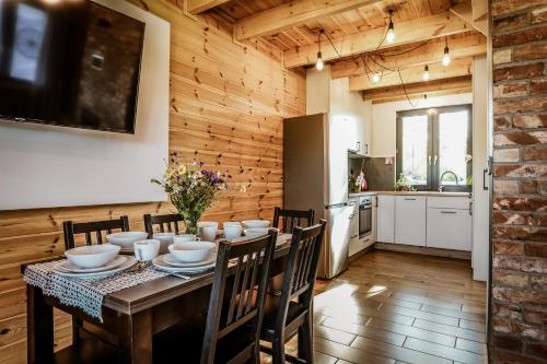 eine Küche und ein Esszimmer mit einem Tisch und Stühlen in der Unterkunft Domki na Kaszubach - Chabry i Rumianki - Roztoka, Przywidz - Basen Sauna Jacuzzi 