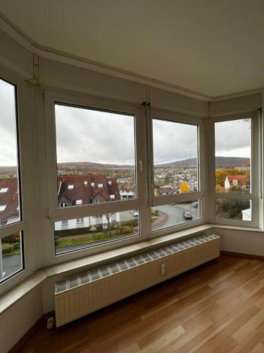 Cette chambre dispose de 3 grandes fenêtres avec vue. dans l'établissement Komplette Wohnung 40m2 mit schöner Terrasse Niedernhausen, à Niedernhausen