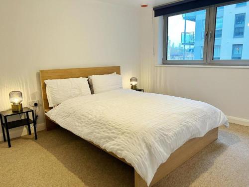 a bedroom with a large white bed with a window at Location, Location, Location with King Size Bed in Kent