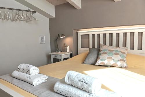 una camera da letto con un grande letto con asciugamani di Vicolo Fiore Affittacamere a Matera