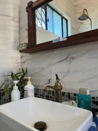 un lavandino bianco in un bagno con specchio di Pasifika Guesthouse a Nadi