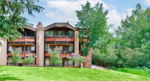 a large house with a balcony on a lawn at Laurelwood Condominiums 105 in Snowmass Village