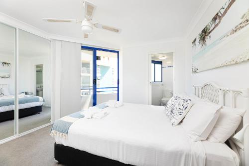a white bedroom with a bed and a window at Heritage 201 in Tuncurry
