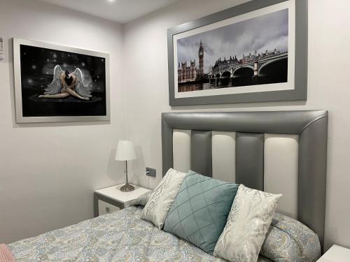 een slaapkamer met een bed en twee foto's aan de muur bij APARTAMENTO 128 ESPINEL in Ronda