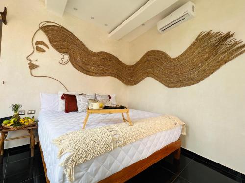 a bedroom with a bed with a painting of a woman at Xkeban Tulum Adults Only in Tulum