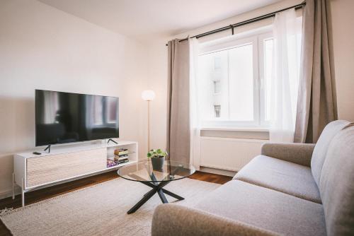 un soggiorno con divano e TV di Sadebo Apartments Lübeck mit Terrasse oder Balkon a Lubecca