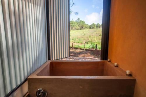 uma banheira em frente a uma janela com vista em Cabaña de lujo muy cómoda, Internet alta velocidad, Fogatero y jardín c/Tina em Mazamitla