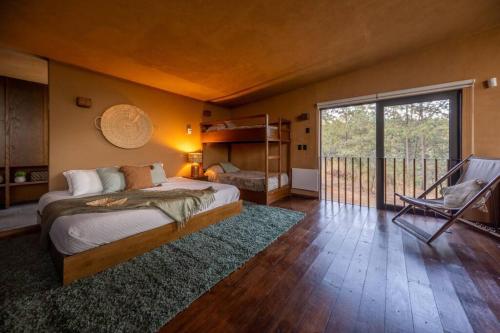 um quarto com uma cama grande e uma varanda em Cabaña de lujo muy cómoda, Internet alta velocidad, Fogatero y jardín c/Tina em Mazamitla