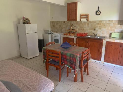a kitchen with a table and chairs and a refrigerator at Logement vacances Gissac Sainte-Anne in Sainte-Anne