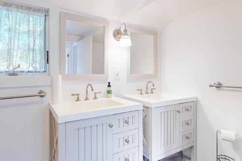 ein weißes Badezimmer mit zwei Waschbecken und einem Spiegel in der Unterkunft Canary Cottage in Oak Bluffs