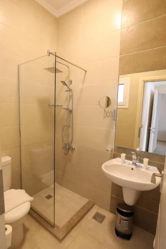 a bathroom with a shower and a sink and a toilet at Marom Port Said Resort & Beach in Port Said