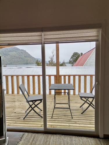 a patio with a table and chairs on a deck at Departamento Rossbach in Puerto Puyuhuapi